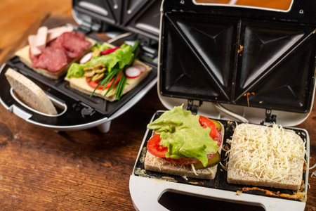 Vegetarian and meat-eating sandwich. Comparison. Sandwich stuffed with meat sausages and ham against a stuffing of lettuce, onion, olives and tomato.の写真素材