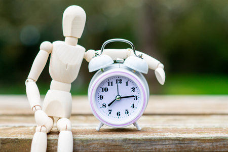 Figure of a man and an alarm clock. The concept of time, circadian rhythm, deadline.の写真素材