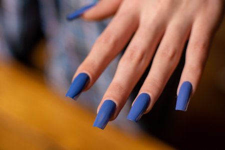 Manicure with long blue nails. Woman's hand close up.の写真素材