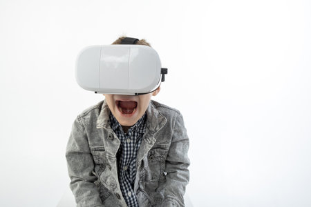 Virtual reality glasses on a young boy in shock. Fun with 3D glasses.の写真素材