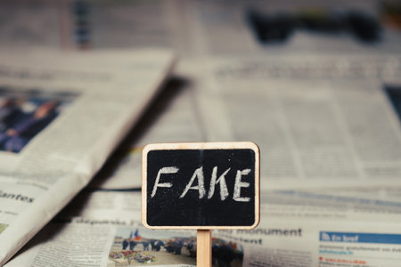 Fake news concept. Sign with the inscription fake on the background of the newspaper.の写真素材
