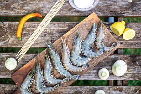 Large king raw prawns on wooden background. Preparation for grilling.の写真素材