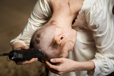 A woman changes her hairstyle by cutting her hair completely.の写真素材