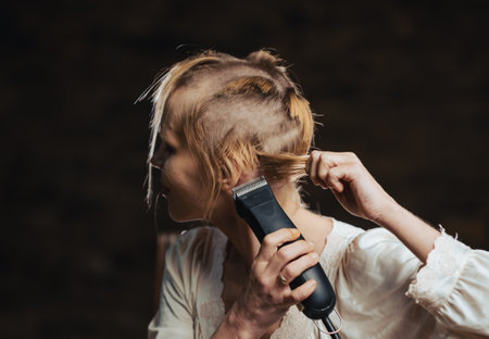 A woman shaves her hair with a clipper. A radical bold change of image. freedom of desire.
