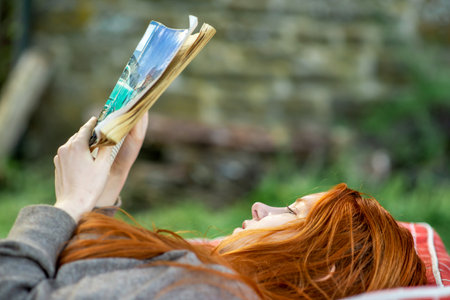 Reading a book outdoors. Relaxation, pleasant weekend getaway. Calm state.の写真素材