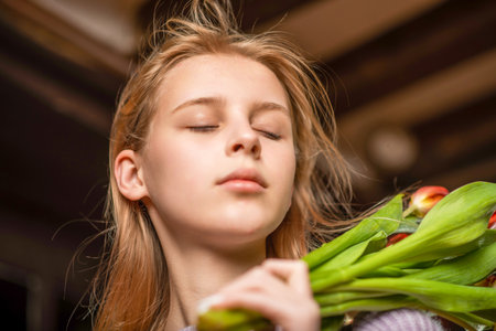 Portrait of a young girl with closed eyes on a dark background.の写真素材