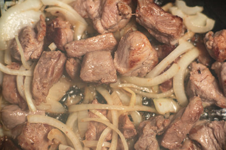 Fried meat goulash with carrots and onions. Braised meat in a frying pan.の写真素材