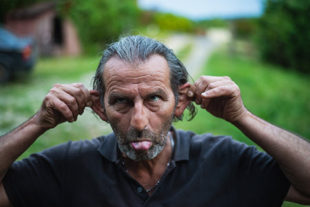 Out in the open, a cheerful 60-year-old man, sporting glasses and long locks, with Serbian heritage,...