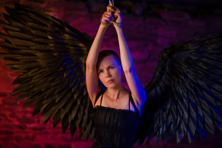 Black angel dot woman with her hands tied and tied to the ceiling. BDSM, adult gamesの写真素材