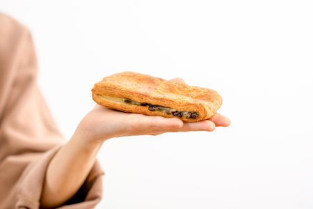 Tender hands holding a delicious puff pastry on a white backgroundの写真素材