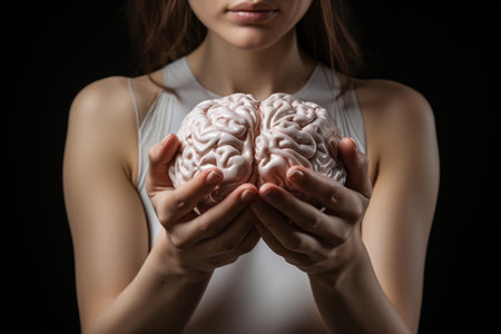 Delicate hands of a woman hold a human brain, highlighting the complex spectrum of neurodiversity, human intellect, and distinct mental abilitiesの素材