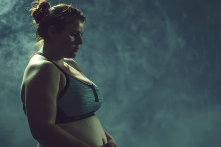 A pregnant woman confidently stands in smoke wearing a bikini, embodying strength and beauty during this special time.の素材