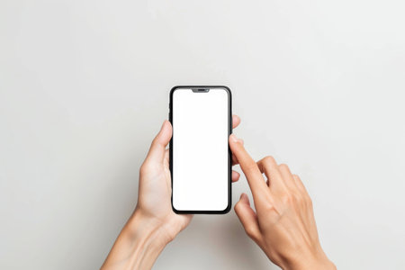 A persons hands hold a phone with a blank white screen, symbolizing the potential for digital connectivity and communication.の素材