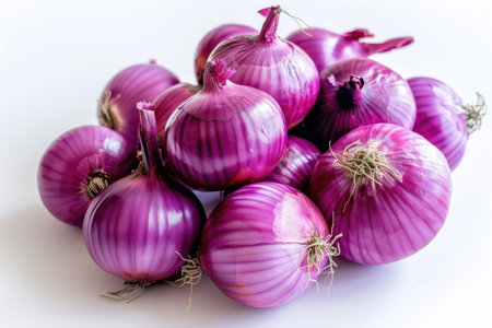 A bunch of purple onions are piled on top of each other. The onions are fresh and ready to be used in a mealの素材