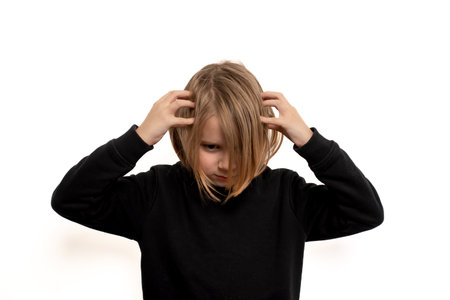 Ten-year-old with long locks, wide-eyed in shock, set against a spotless white background