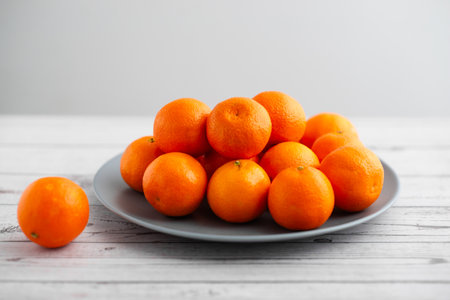 Plate of mandarins on a light wooden backgroundの写真素材