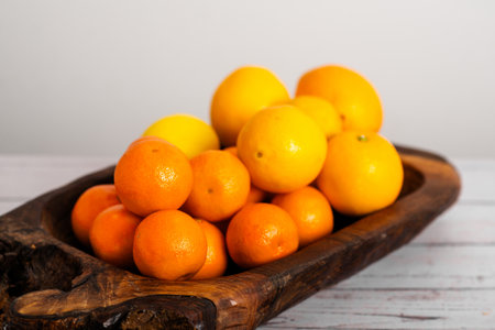 Citrus medley in a wooden dish, a vibrant display of vitamin-rich goodnessの写真素材