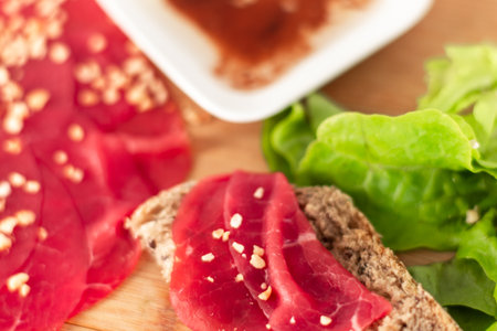 A plate of meat and bread with a bowl of sauce next to it. Scene is casual and inviting, as it looks like a simple and delicious mealの写真素材
