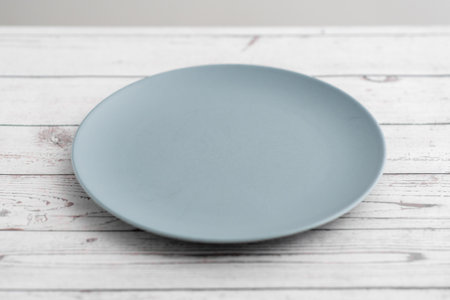 Empty plate on a wooden background, ready for a culinary masterpieceの写真素材