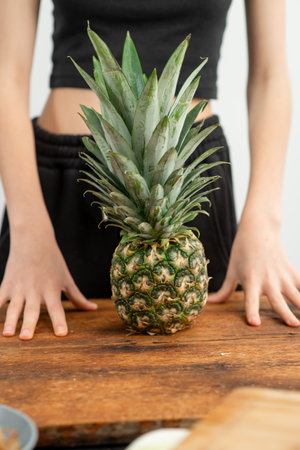 Hands showcasing a pineapple, suggesting tropical freshness and taste.の写真素材
