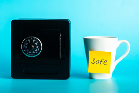 Contrasting concepts: secure safe box and labeled cup safety on blue background.の写真素材