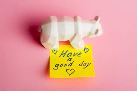 Geometric white rhino on pink background with positive message note.の写真素材