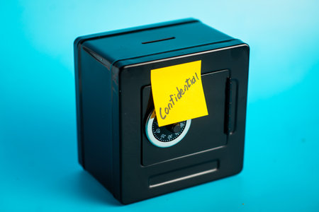 Secure safe with confidential sticky note on blue background.の写真素材
