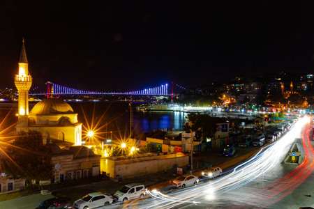 Istanbul, Turkey - September 6, 2018: Long exposure shot of Semsi Pasha Mosque and 15 July Martyrs Bridge in the background. Passing traffic created a light trail effect.のeditorial素材