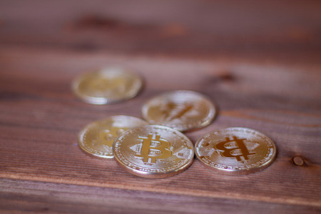 Bitcoins on a wooden background. A concept from coins of the cryptocurrency.