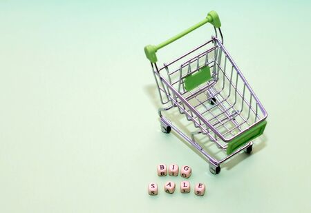 Shopping trolley and word big sale from cubes on a green background.の写真素材