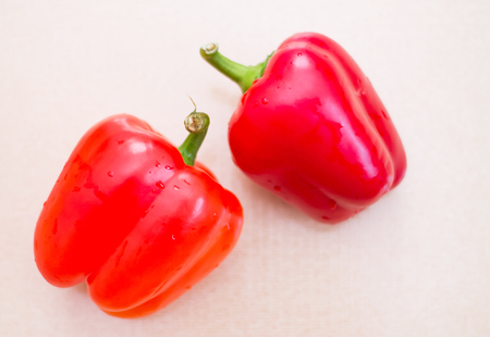 Two red sweet peppers with drops of water. Fresh vegetables for a healthy diet.の写真素材