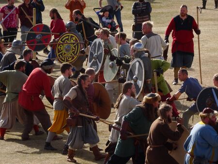 Large Viking battle reenactment at icelandic viking festival in Hafnarfjoerdur. Two armies fighting in traditional cloth with swords, shields and pikes. Shot in sunny daylight. Editorial picture.のeditorial素材