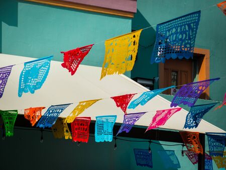 Traditional and colorful mexican banners hanging over San Antonio Mercado for October festival. Turquoise market building in background on sunny summer day. No people.の写真素材
