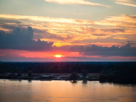Beautiful sunset over Mississippi River with reflections in water, shot in Natchez, MS. Clouds visible. Copyspace.の写真素材