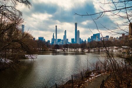 Lake in Central Park with Skyline of Manhattan in background. Dramatic, cloudy sky in New York City, NY. No people visible.の写真素材