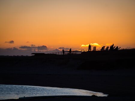 Silhouette of people watching dramatic sunset on Nautholsvik geothermal beach in Reykjavik, Iceland. Spring evening, atlantic ocean visible. Copyspace.の写真素材
