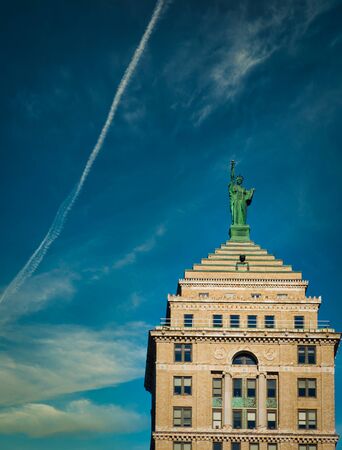 Rooftop of Liberty Building with replica of Lady Liberty in Bufallo, New York State. Blue sky with few clouds, sunny summer day. No people visible, upwards shot, copyspace.の写真素材