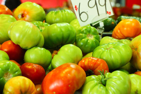 Pile of delicious looking tomatoes on display at a local marketの写真素材