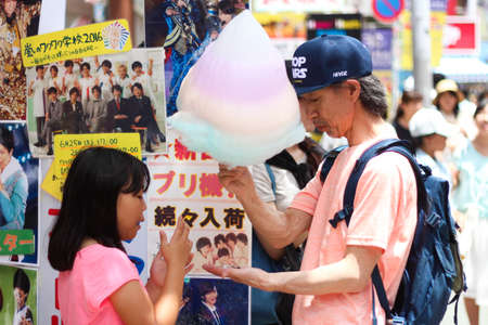 Father and daughter sharing a giant rainbow cotton candy in Harajuku Tokyoのeditorial素材