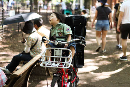 Toddler asleep in the child seat of a bicycleのeditorial素材