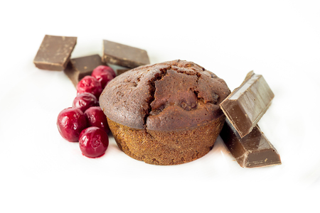 Chocolate muffin with sour cherries isolated on white backgroundの写真素材