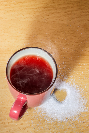 Cup of tea with heart-shaped sugar on wooden backgroundの写真素材
