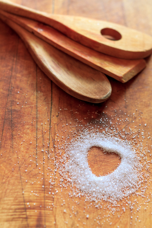 Heart-shaped sugar on cutting board with wooden utensils. I love cooking concept.の写真素材