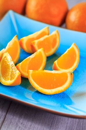 Fresh slices of orange served on blue plateの写真素材