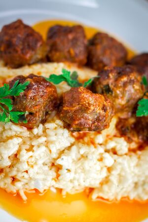 Meatballs with rice and parsley on white plateの写真素材
