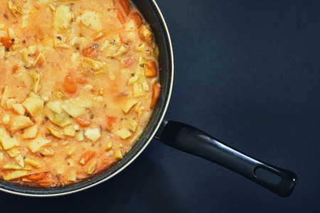 Cooked vegan green beans stew in black pan on dark background. Top view with copy spaceの写真素材