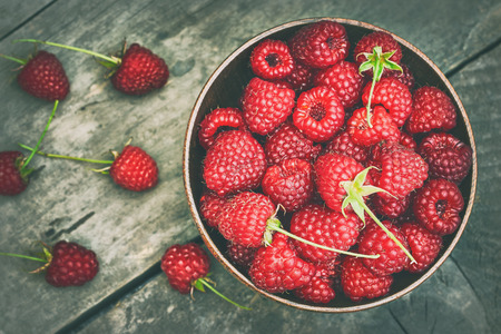 Fresh raspberries in wooden bowl on grey rustic wooden background. Top viewの写真素材