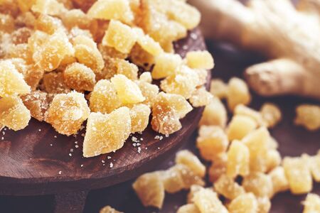 Pile of candied ginger on brown wooden backgroundの写真素材