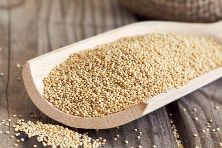 Amaranth grain in wooden scoop on rustic backgroundの写真素材