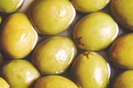 Closeup of pickled green olives background. Top viewの写真素材